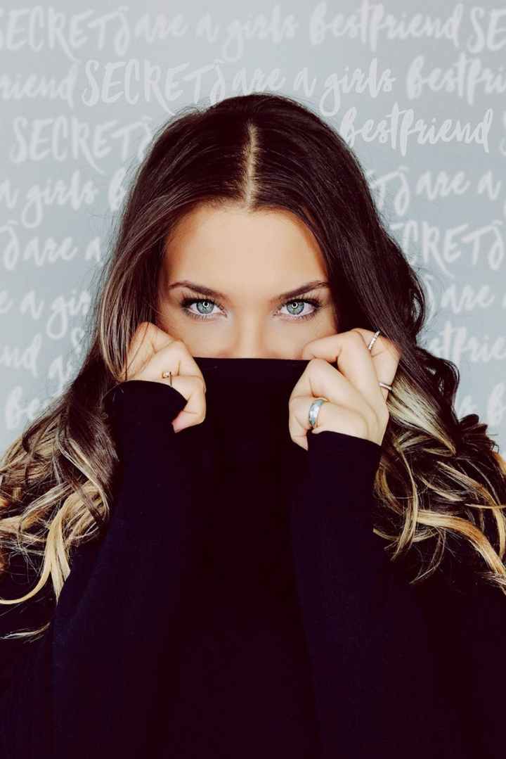 woman in purple sweater covering her face