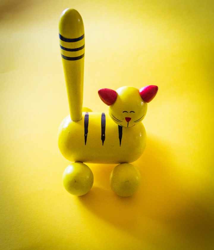yellow and red cat figurine on yellow top